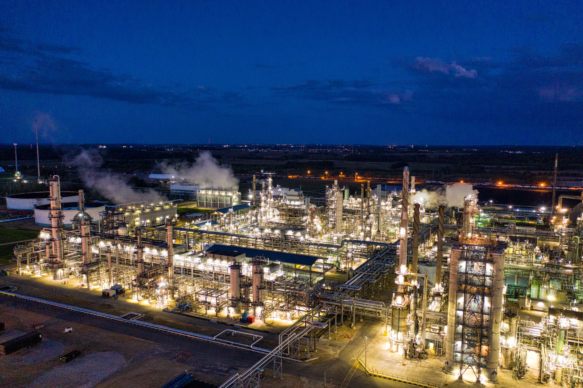 Instalación industrial de refinación iluminada al anochecer
